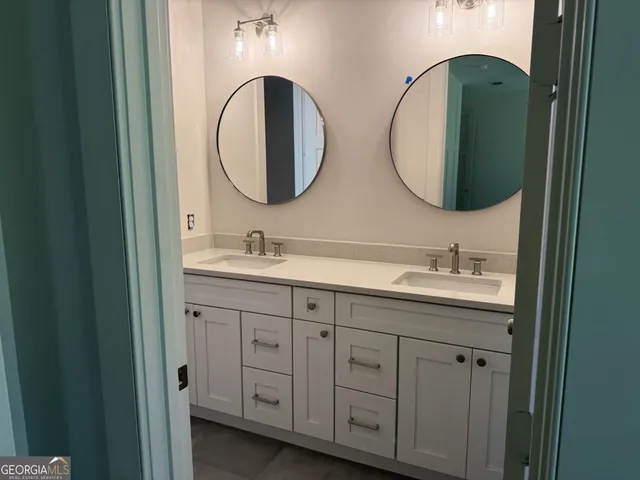 an empty room with wooden floor and fan