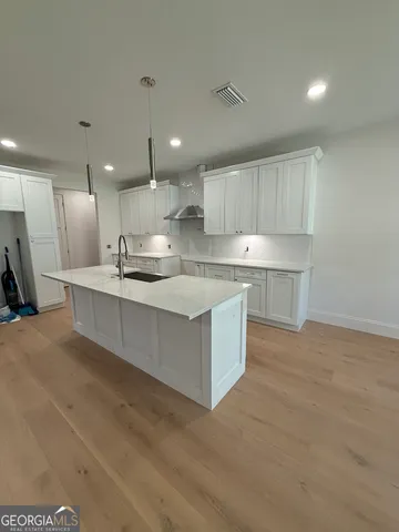 a kitchen with kitchen island a sink stove and cabinets