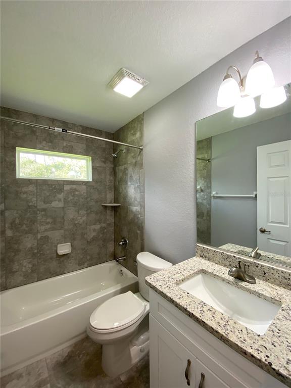 2458 Southwest 170th Loop Ocala, FL 34473 - Photo 12 of 25 a bathroom with a granite countertop sink toilet mirror and bathtub
