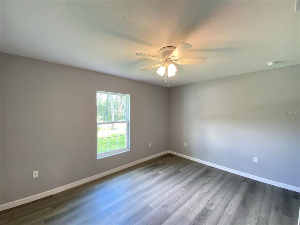 2458 Southwest 170th Loop Ocala, FL 34473 - Photo 14 of 25 an empty room with wooden floor and windows
