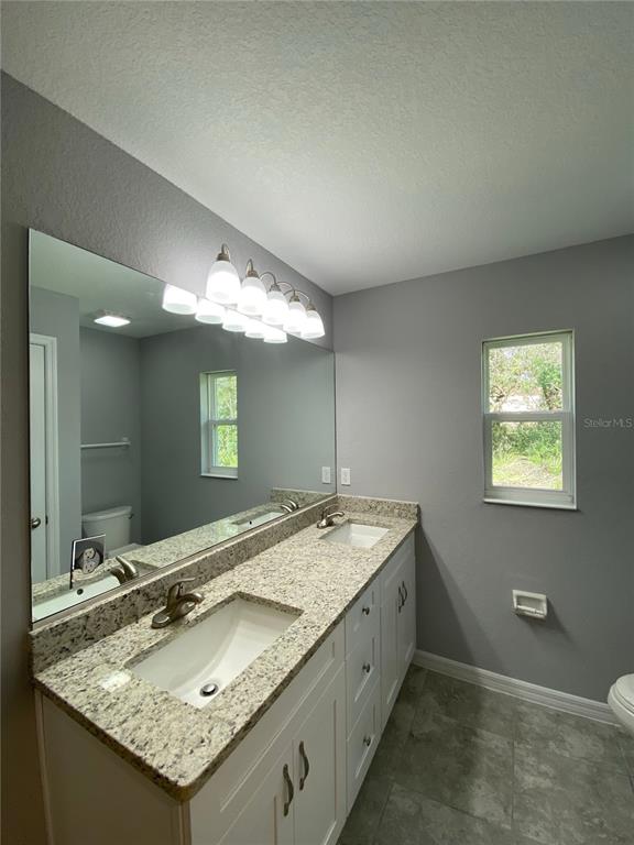 2458 Southwest 170th Loop Ocala, FL 34473 - Photo 18 of 25 a bathroom with a granite countertop sink and a mirror