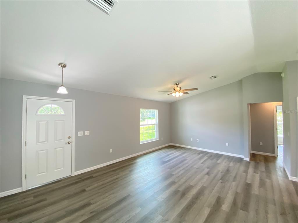 2458 Southwest 170th Loop Ocala, FL 34473 - Photo 2 of 25 an empty room with wooden floor and window