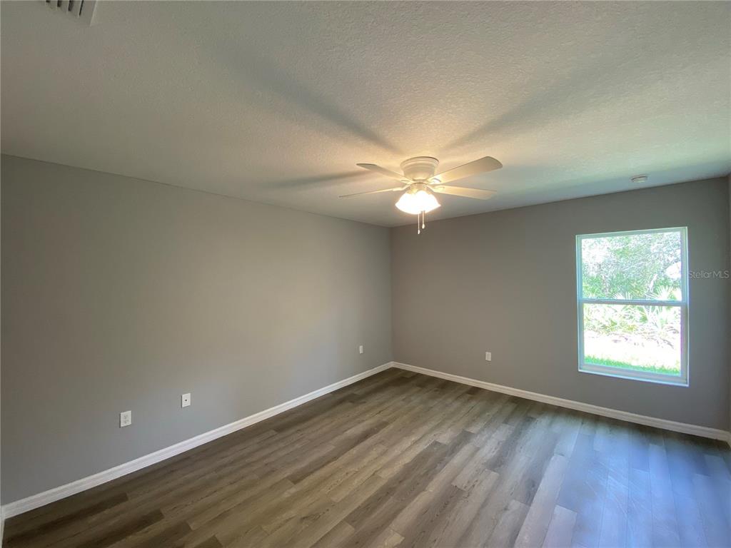 2458 Southwest 170th Loop Ocala, FL 34473 - Photo 21 of 25 wooden floor in an empty room with a window