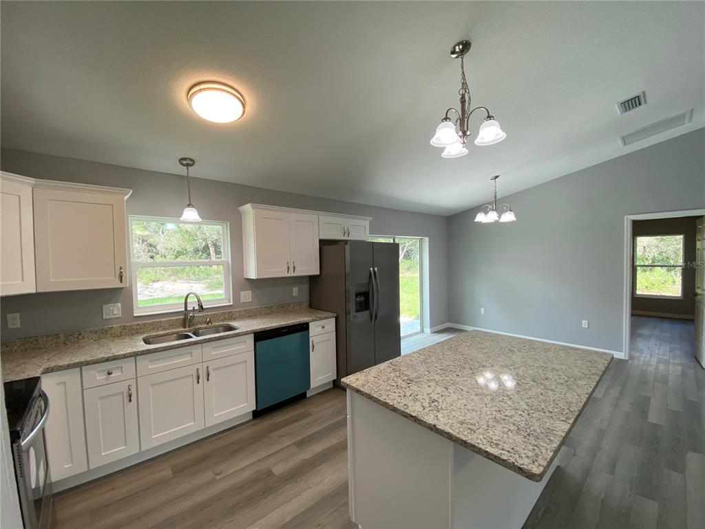 2458 Southwest 170th Loop Ocala, FL 34473 - Photo 5 of 25 a kitchen with stainless steel appliances granite countertop a sink window and cabinets