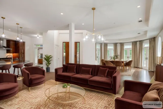 a living room with furniture kitchen and a chandelier