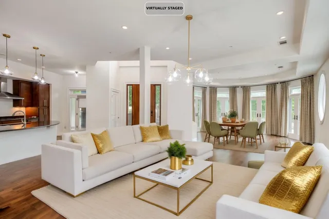 a living room with furniture kitchen view and a chandelier