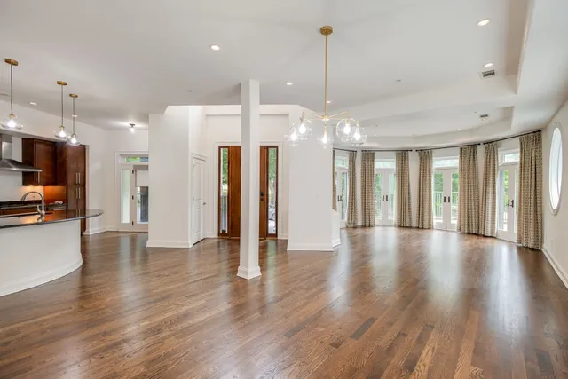 a view of an empty room and kitchen with stainless steel appliances