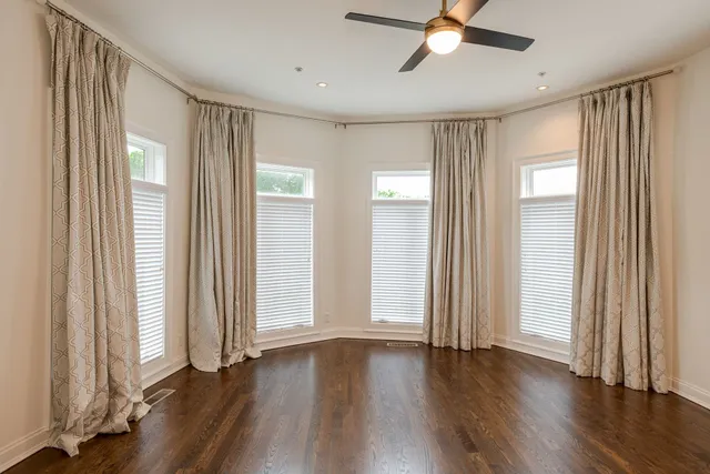 a view of a livingroom with wooden floor and a ceiling fan