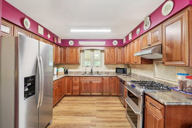 a kitchen with stainless steel appliances granite countertop a refrigerator and microwave