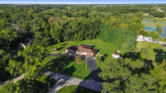 an aerial view of residential houses with outdoor space and trees all around