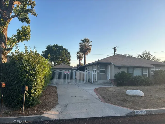 a view of a house with a yard and potted plants