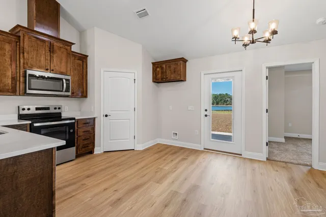 a kitchen with granite countertop wooden floors and stainless steel appliances