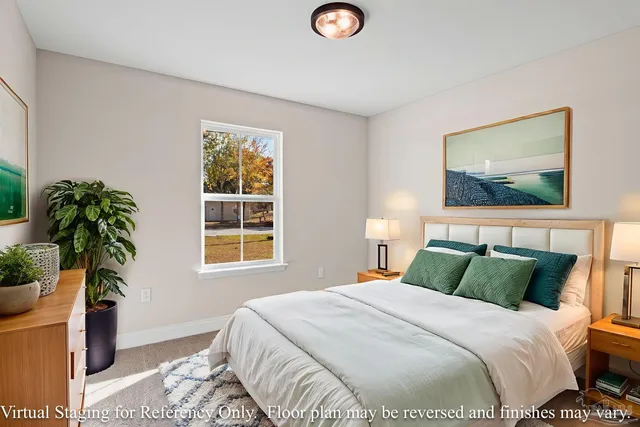 a bedroom with a bed and a potted plant