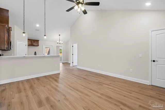 wooden floor in an empty room with a kitchen