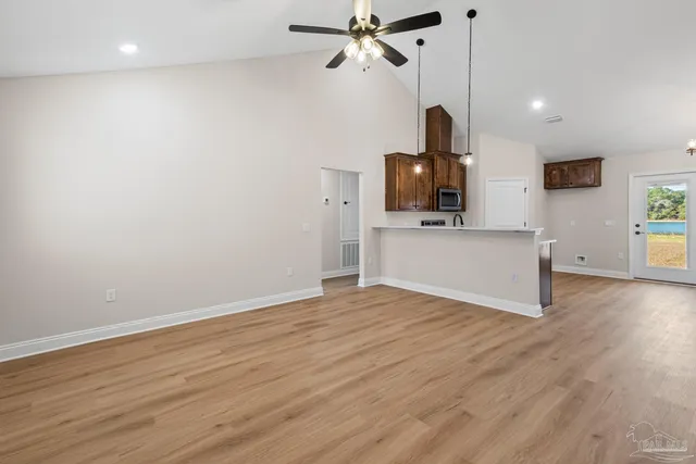 a view of a kitchen with wooden floor and a ceiling fan