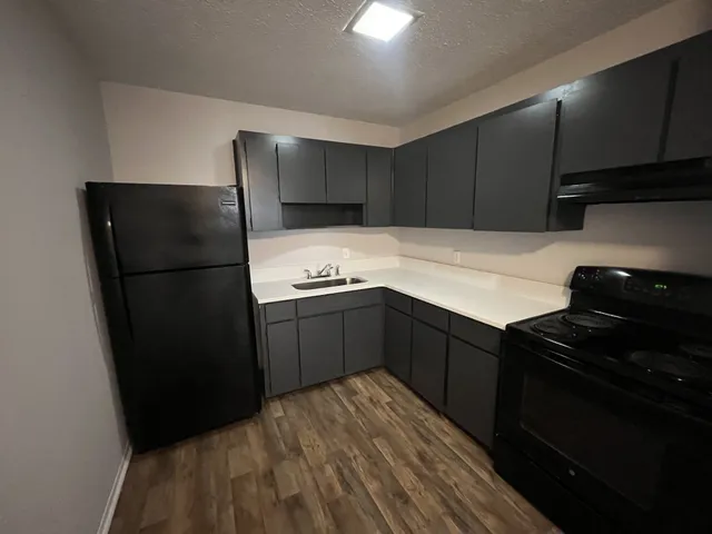 a kitchen with a refrigerator and a stove