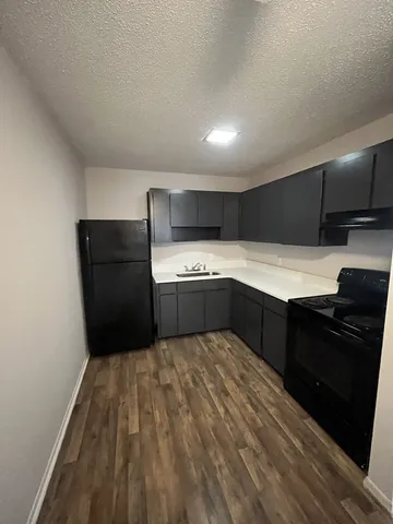 a kitchen with a refrigerator and a stove top oven