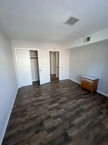 a view of empty room with wooden floor