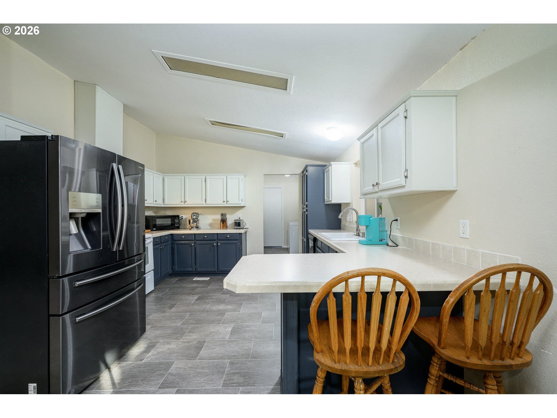 1282 3rd Street, Unit 83 Lafayette, OR 97127 - Photo 17 of 45 a kitchen with stainless steel appliances a refrigerator a stove a sink cabinets and a dining table