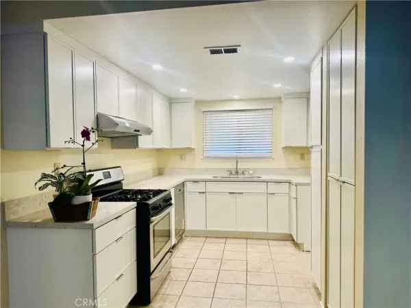 a kitchen with a sink a stove and cabinets