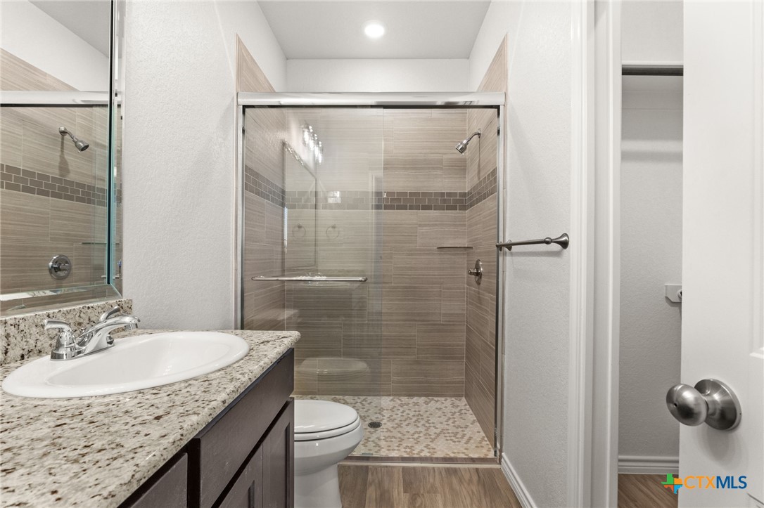 102 Levi Court, Unit B Copperas Cove, TX 76522 - Photo 7 of 9 a bathroom with a granite countertop sink toilet and shower