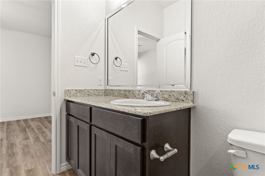 102 Levi Court, Unit B Copperas Cove, TX 76522 - Photo 8 of 9 a bathroom with a granite countertop sink and a toilet