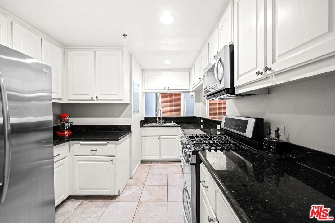a kitchen with stainless steel appliances a stove a sink and a refrigerator