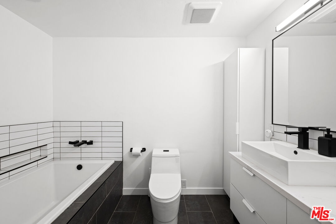 1401 South Bentley Avenue, Unit 202 Los Angeles, CA 90025 - Photo 16 of 32 a bathroom with a toilet sink and mirror