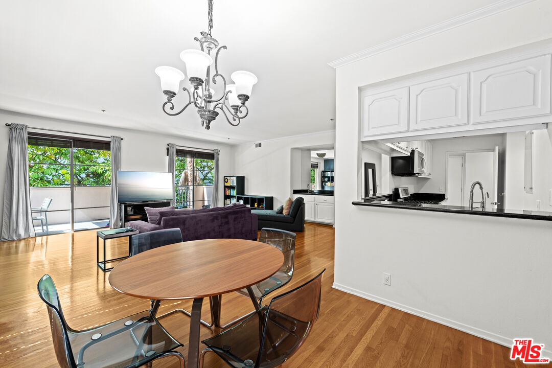 1401 South Bentley Avenue, Unit 202 Los Angeles, CA 90025 - Photo 8 of 32 a view of a dining room with furniture a chandelier and wooden floor