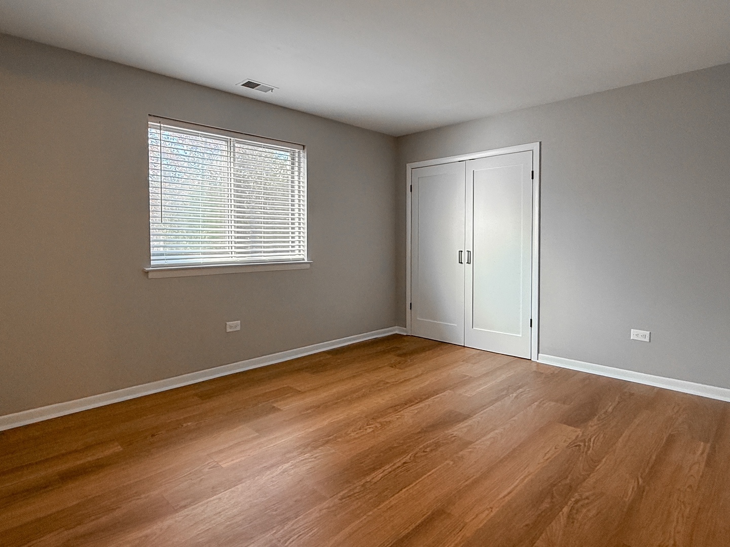 9724 Bianco Terrace, Unit A Des Plaines, IL 60016 - Photo 5 of 13 a view of an empty room with wooden floor and a window