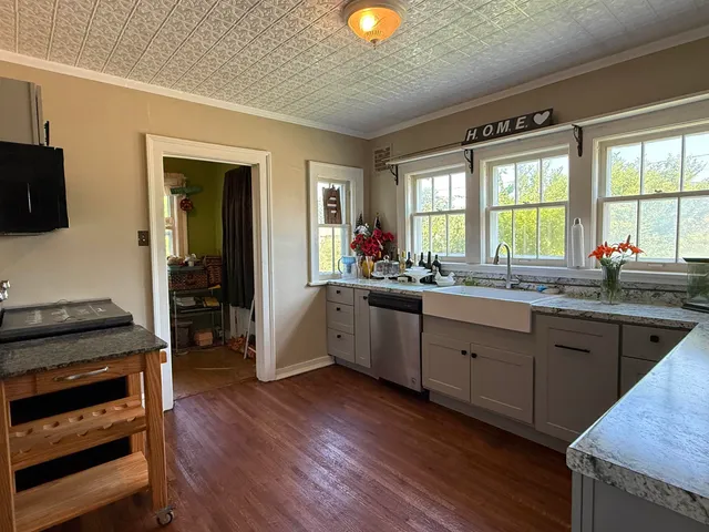 a kitchen with granite countertop wooden cabinets and a stove top oven