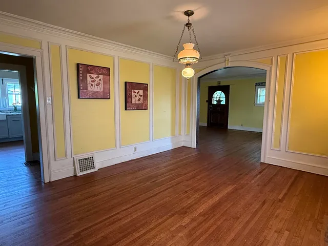 a view of a hallway with wooden floor and a chandelier