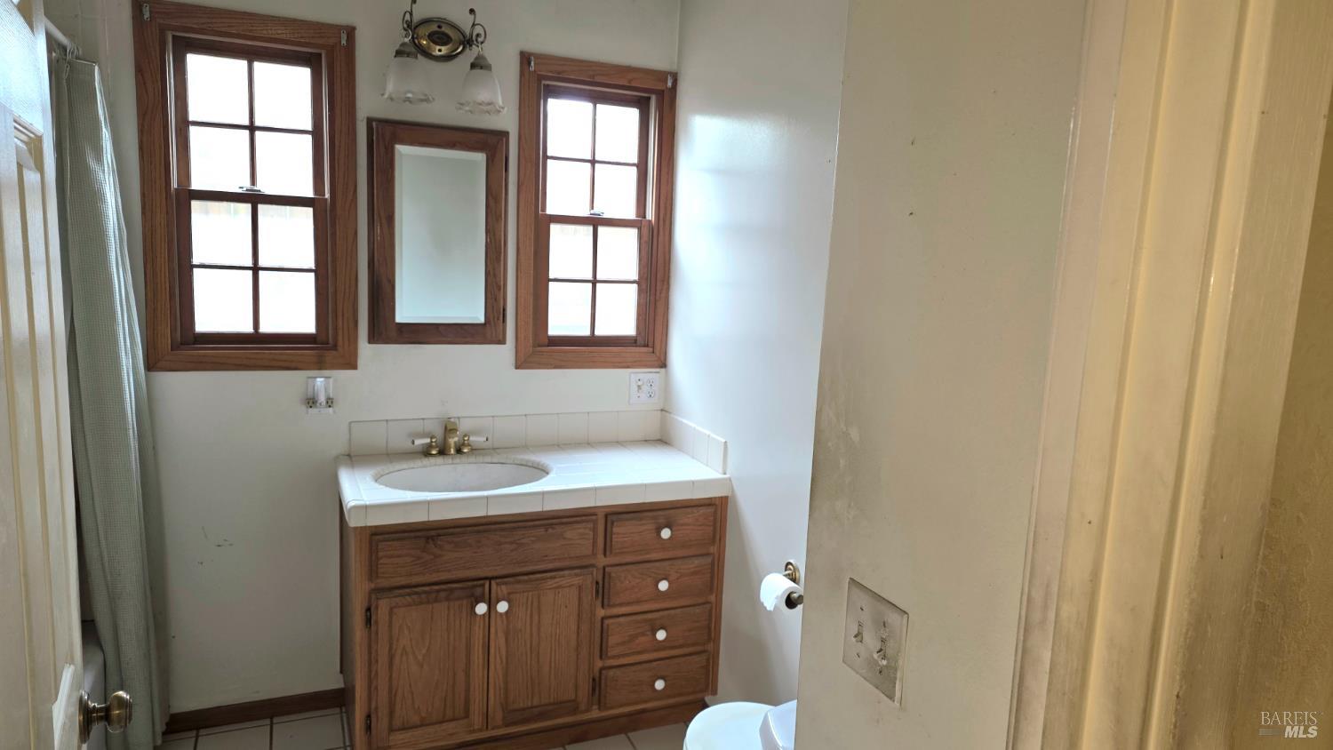 1420 Fulton Road Santa Rosa, CA 95403 - Photo 12 of 17 a bathroom with a sink a vanity and a mirror