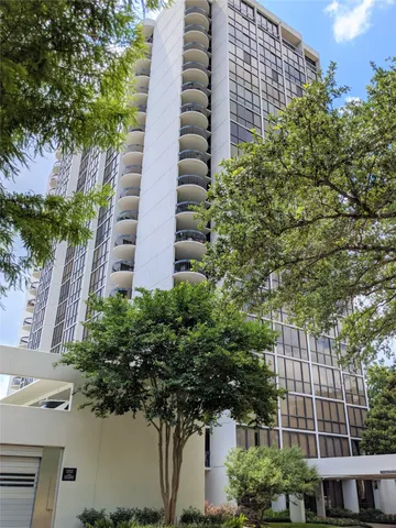 a view of a tall building next to a tree