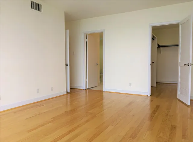 an empty room with wooden floor and closet