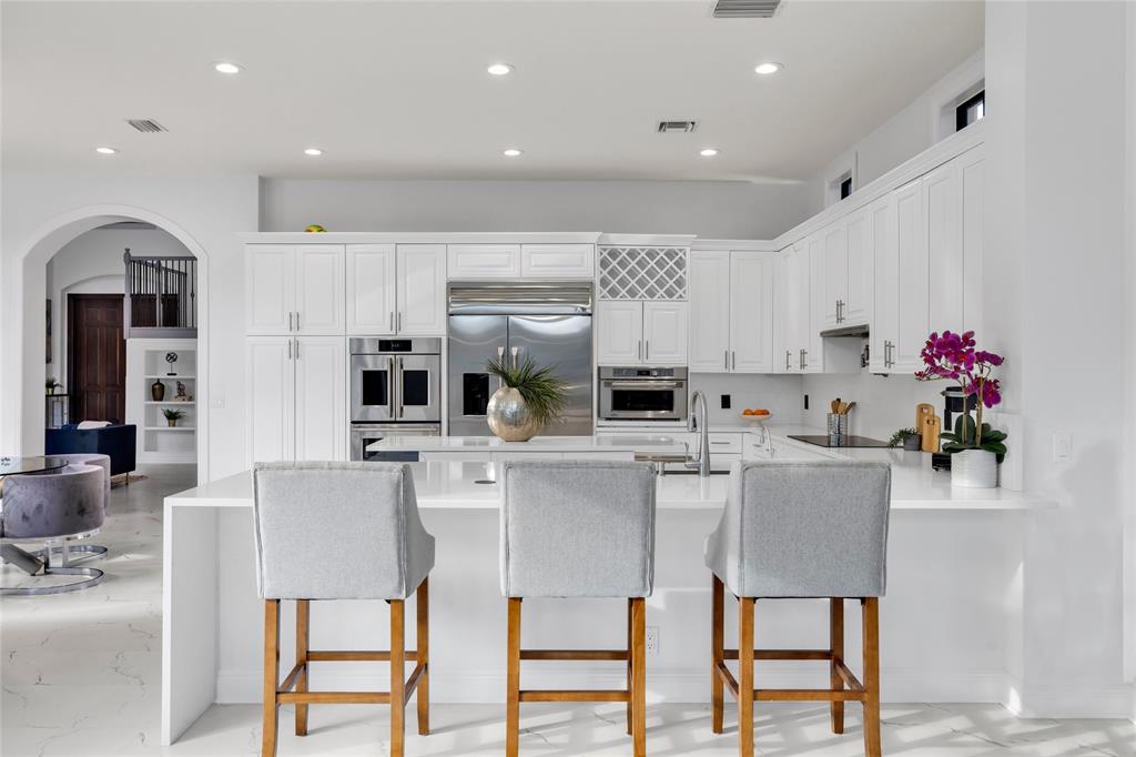 6915 Long Leaf Drive Parkland, FL 33076 - Photo 19 of 80 a kitchen with stainless steel appliances kitchen island granite countertop a table and chairs in it