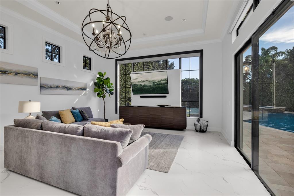 6915 Long Leaf Drive Parkland, FL 33076 - Photo 24 of 80 a living room with furniture a large window and a chandelier