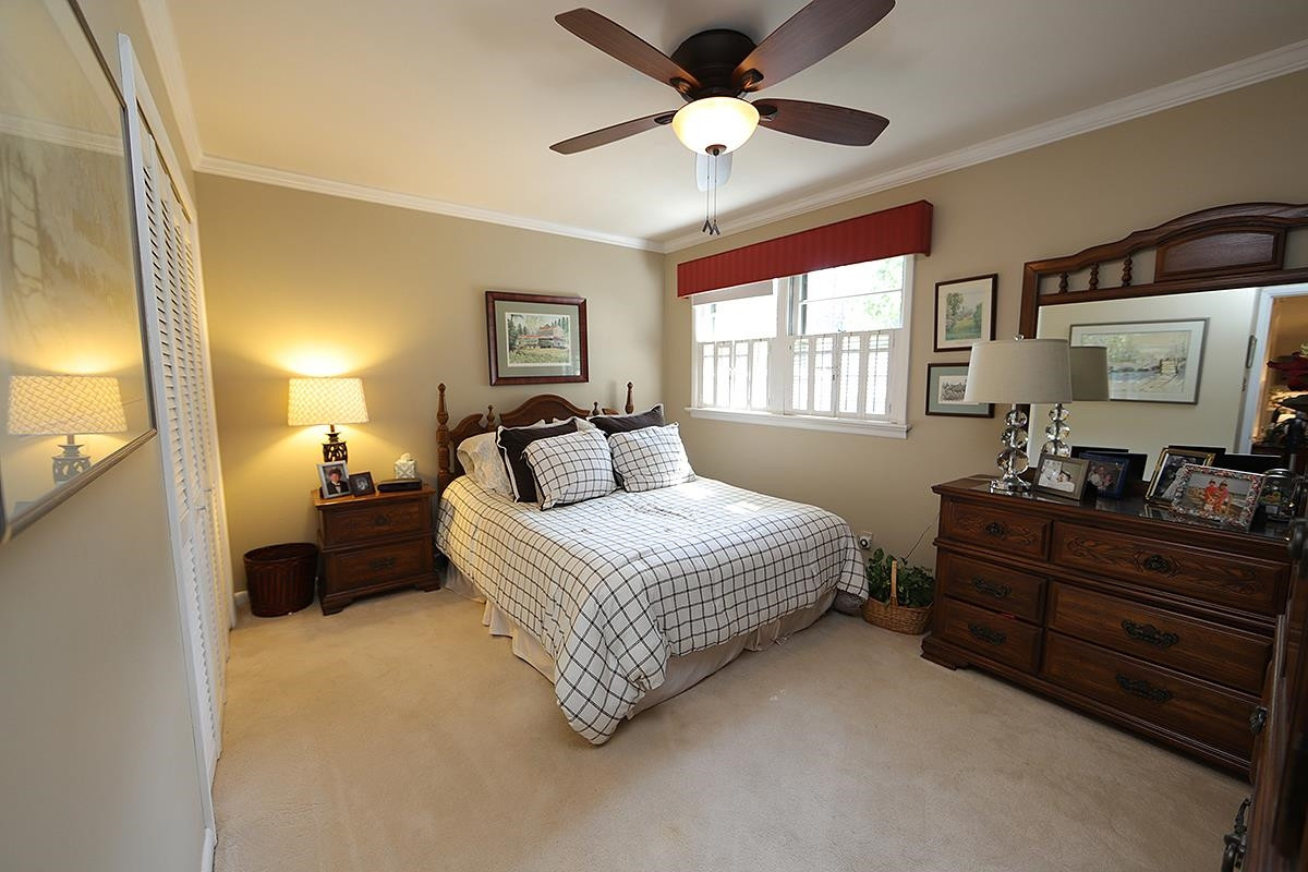 2505 Medway Drive Raleigh, NC 27608 - Photo 12 of 18 a bedroom with a bed and a chandelier