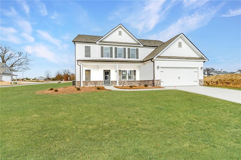 a front view of a house with a garden and yard