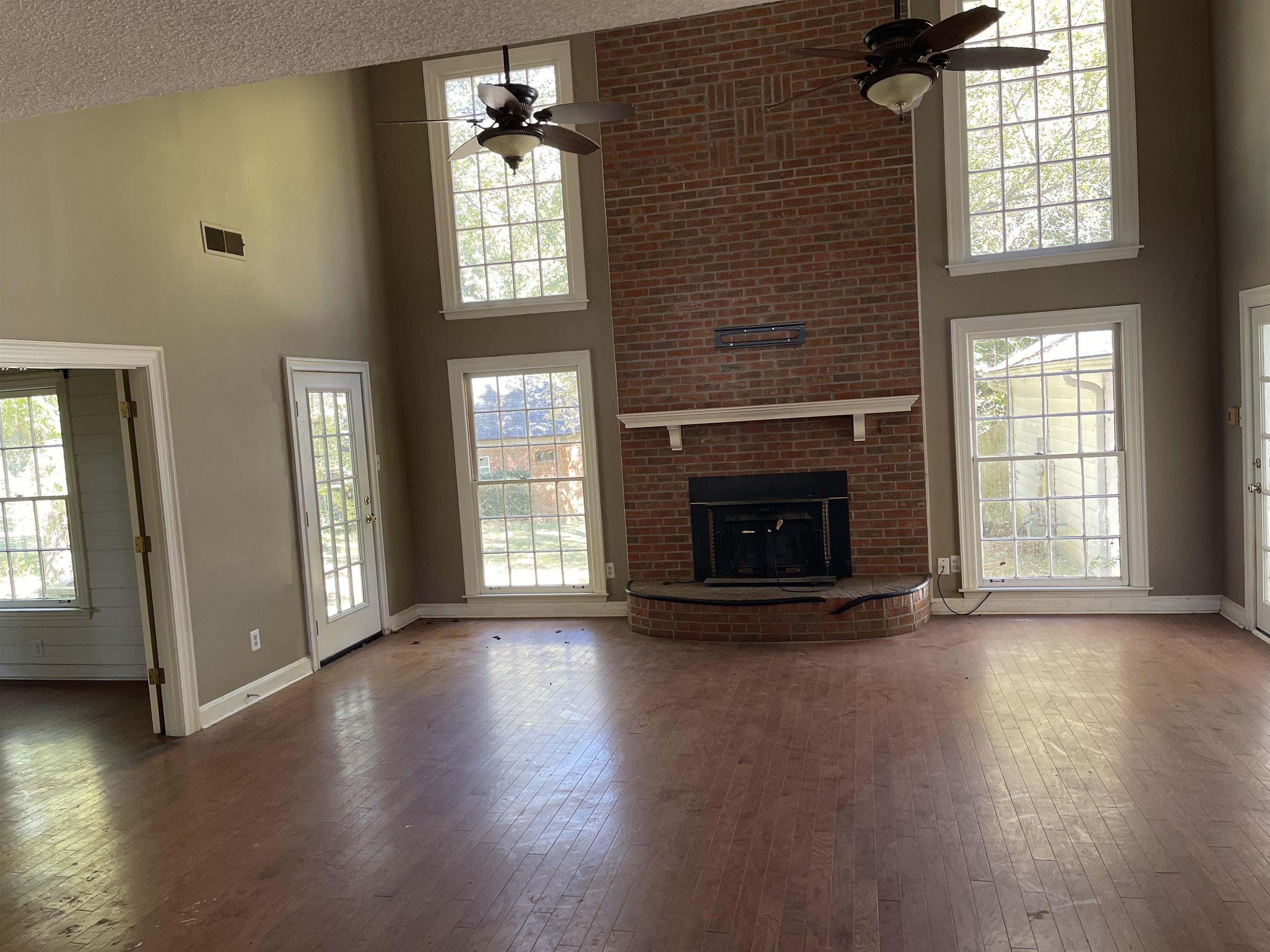 9220 Davies Plantation Road Bartlett, TN 38133 - Photo 6 of 19 Great room with ceiling fan, a high ceiling, a fireplace, and dark hardwood / wood-style flooring