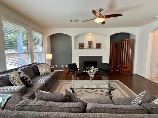a living room with furniture a fireplace and a large window