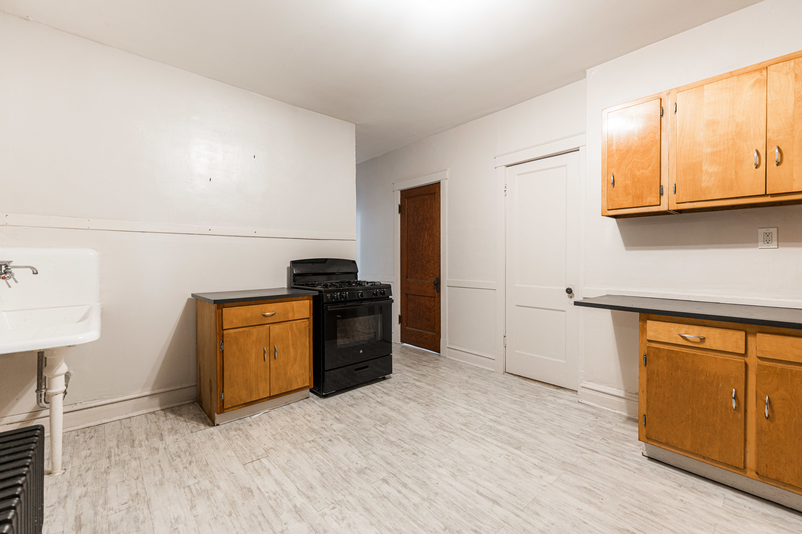 2257 North Springfield Avenue, Unit 1F Chicago, IL 60647 - Photo 12 of 27 a kitchen with granite countertop a refrigerator a stove a sink and dishwasher with wooden floor
