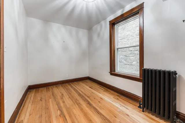 a view of a room with wooden floor and small window