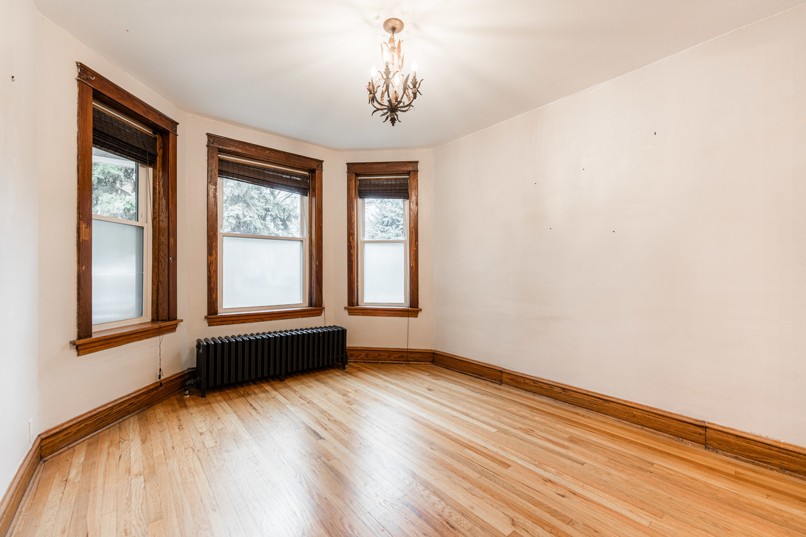 2257 North Springfield Avenue, Unit 1F Chicago, IL 60647 - Photo 4 of 27 an empty room with wooden floor and windows