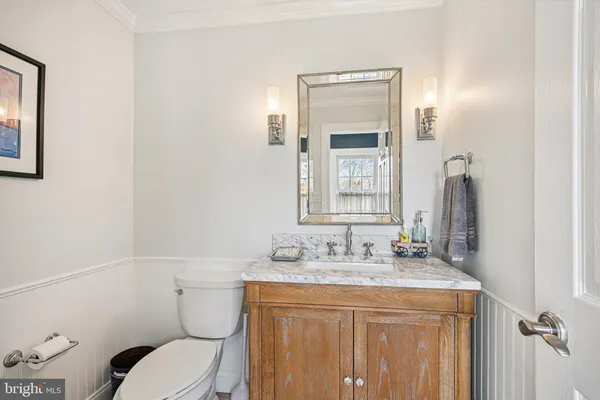 a bathroom with a granite countertop toilet sink and mirror