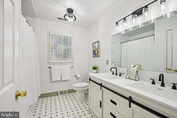 a bathroom with a sink a toilet and a mirror