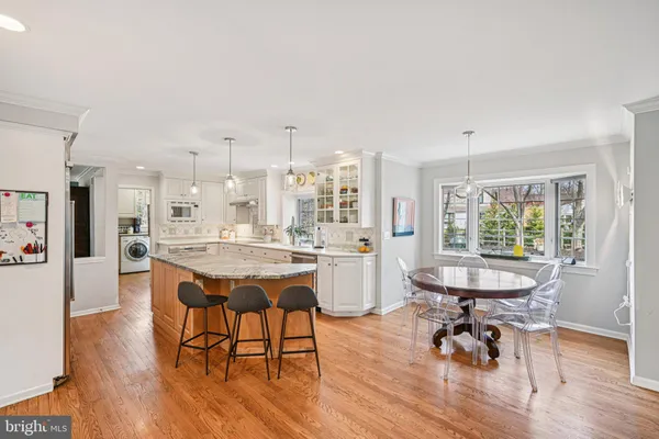 a dining room with a table chairs and a kitchen view