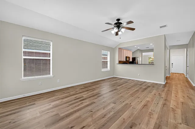 a view of a livingroom with a window and wooden floor
