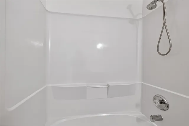 a bathroom with a bath tub with a shower