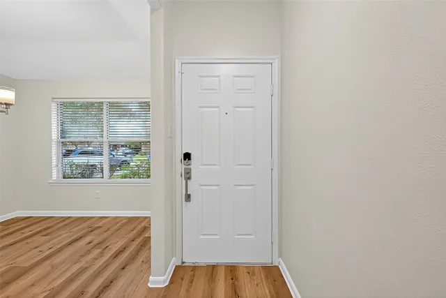 an empty room with wooden floor and a window